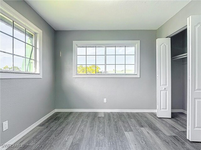 unfurnished bedroom with wood-type flooring and a closet