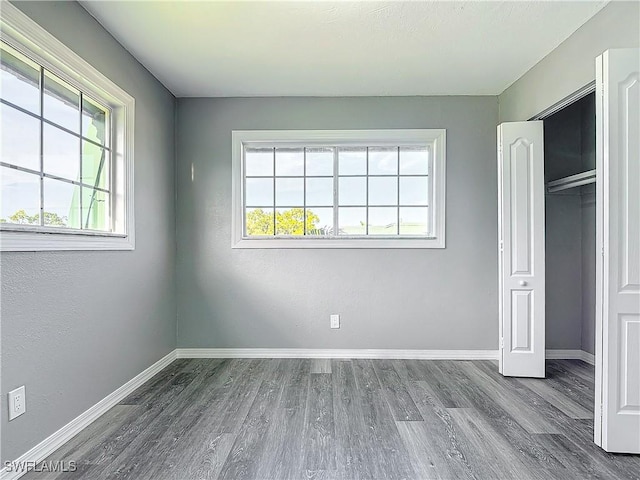 4802 Albacore Ln, Fort Myers, FL 33919 - unfurnished bedroom featuring multiple windows, wood finished floors, baseboards, and a closet
