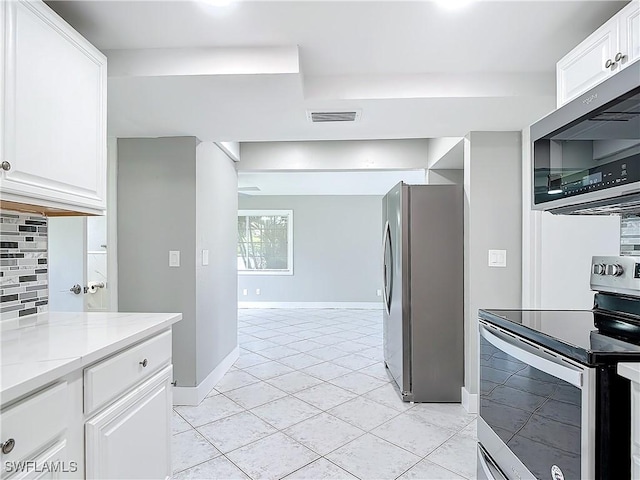 kitchen featuring white cabinetry, light stone counters, tasteful backsplash, and appliances with stainless steel finishes