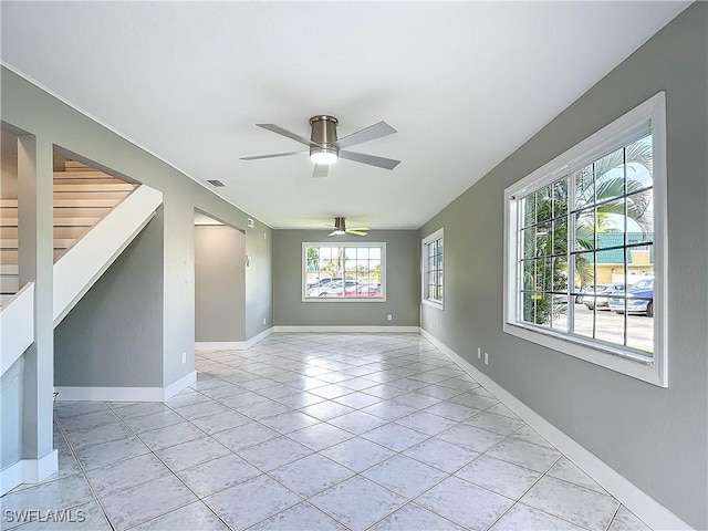 empty room with ceiling fan and light tile patterned flooring