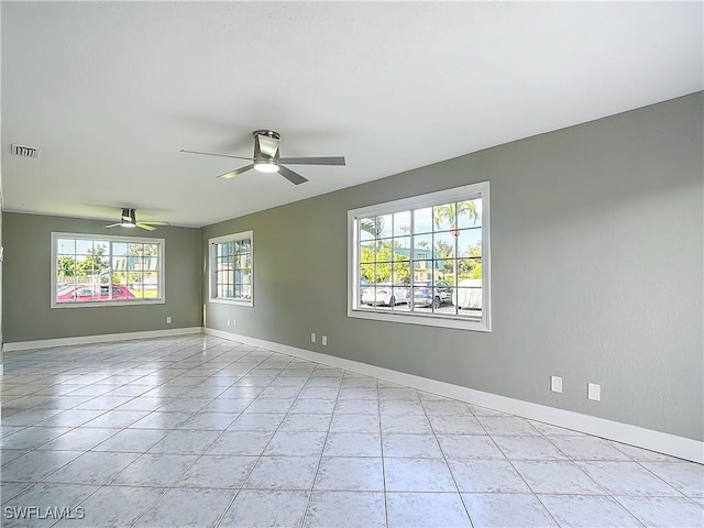 tiled empty room featuring ceiling fan