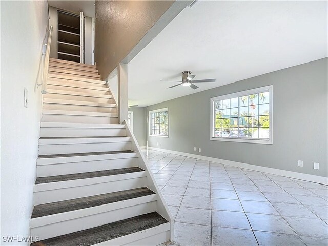 stairs with tile patterned floors and ceiling fan