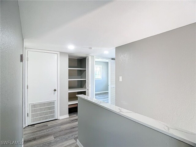 corridor with hardwood / wood-style floors