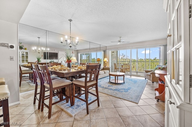 tiled dining room with a textured ceiling and ceiling fan with notable chandelier