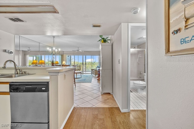 kitchen with ceiling fan with notable chandelier, decorative light fixtures, dishwasher, light hardwood / wood-style flooring, and sink