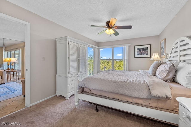 carpeted bedroom featuring ceiling fan and a textured ceiling