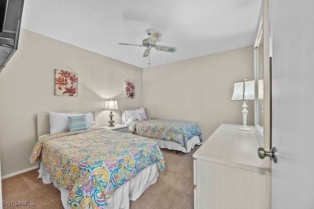 bedroom featuring ceiling fan, light colored carpet, and a textured ceiling