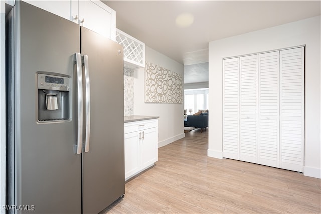 kitchen with white cabinets, stainless steel refrigerator with ice dispenser, and light hardwood / wood-style floors