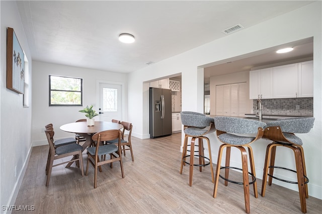 dining space with sink and light hardwood / wood-style floors