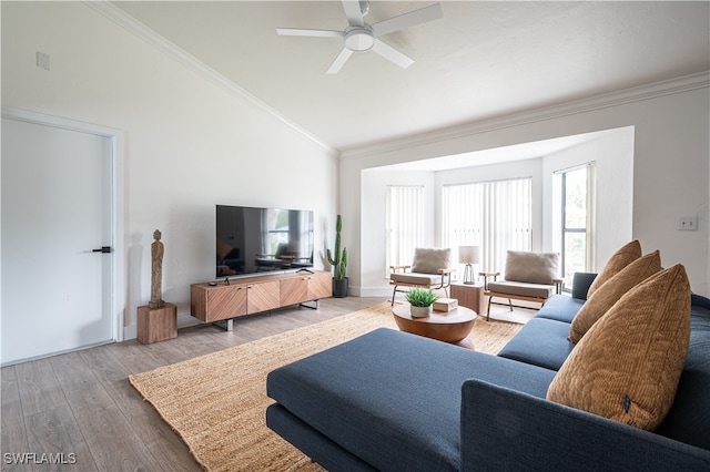 living room with light hardwood / wood-style flooring, vaulted ceiling, ceiling fan, and crown molding