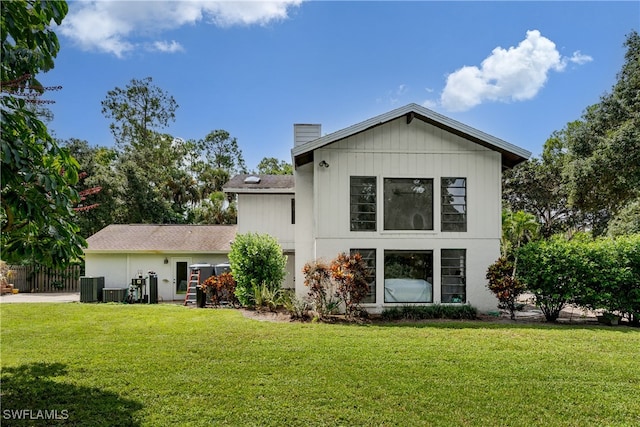 rear view of property with a yard and central AC unit