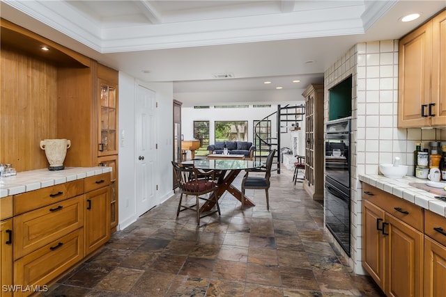 kitchen featuring ornamental molding, tasteful backsplash, and tile counters