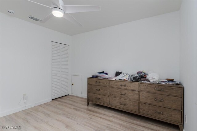 bedroom featuring light hardwood / wood-style flooring, ceiling fan, and a closet