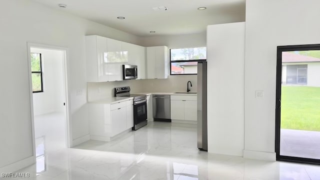 kitchen with white cabinets, appliances with stainless steel finishes, and sink