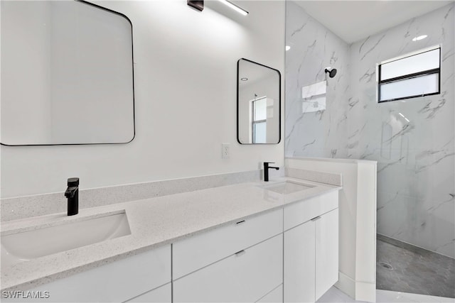 bathroom featuring tiled shower and vanity