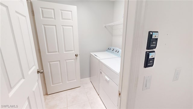 laundry room with washer and clothes dryer and light tile patterned flooring