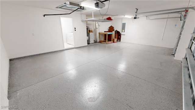 garage featuring a garage door opener, washing machine and dryer, electric panel, and water heater