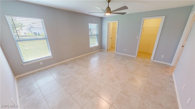 unfurnished room with light tile patterned floors and ceiling fan