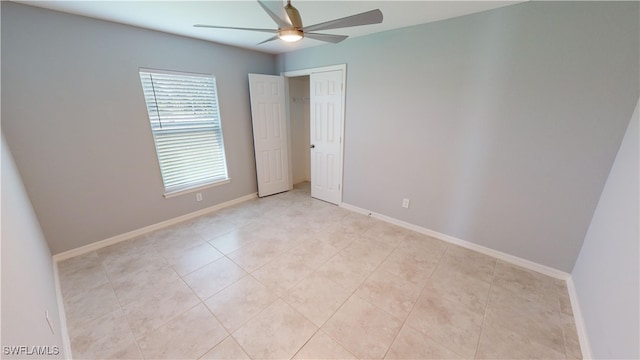 tiled spare room with ceiling fan