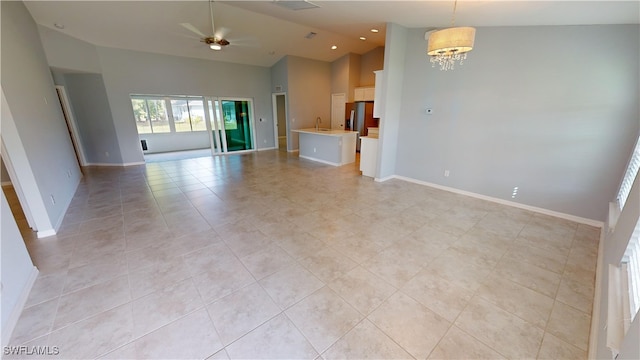 unfurnished living room featuring light tile patterned floors, ceiling fan with notable chandelier, and high vaulted ceiling