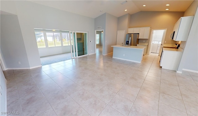 interior space with high vaulted ceiling and light tile patterned flooring