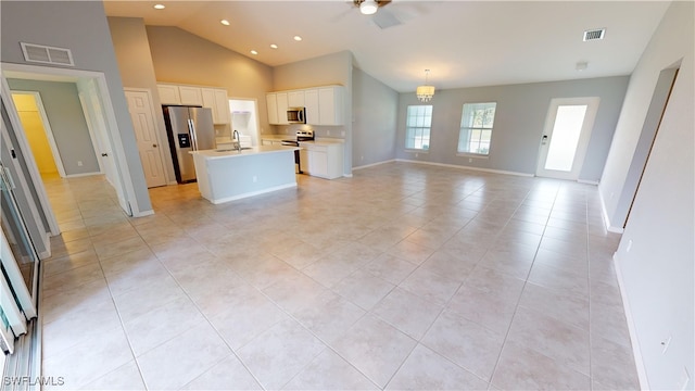 unfurnished living room featuring high vaulted ceiling, light tile patterned flooring, sink, and ceiling fan