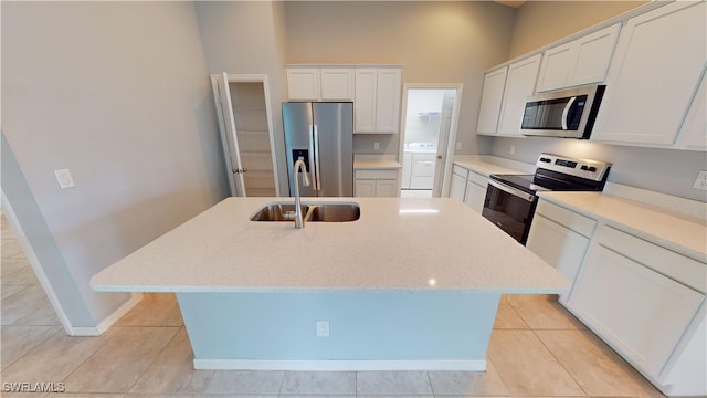 kitchen featuring white cabinets, stainless steel appliances, an island with sink, and sink