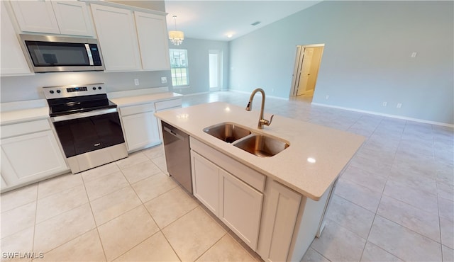 kitchen featuring an inviting chandelier, decorative light fixtures, appliances with stainless steel finishes, sink, and a kitchen island with sink