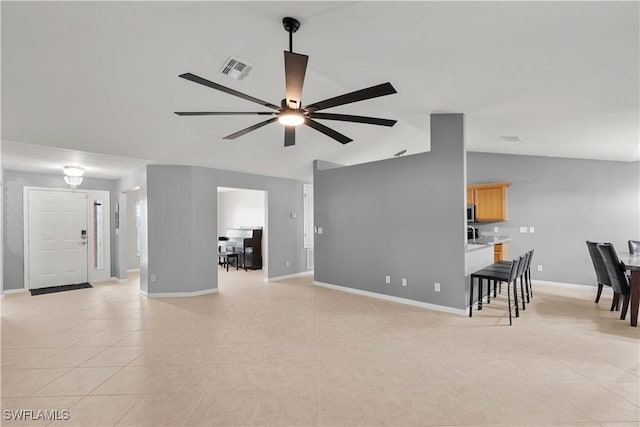 tiled living room featuring ceiling fan and lofted ceiling