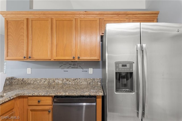 kitchen featuring appliances with stainless steel finishes and light stone counters