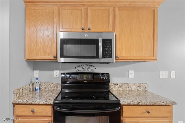 kitchen featuring light stone countertops, light brown cabinets, and electric range