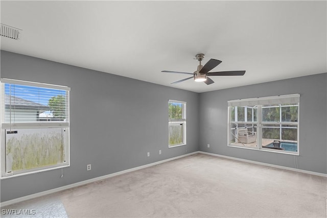 unfurnished room with light colored carpet and ceiling fan