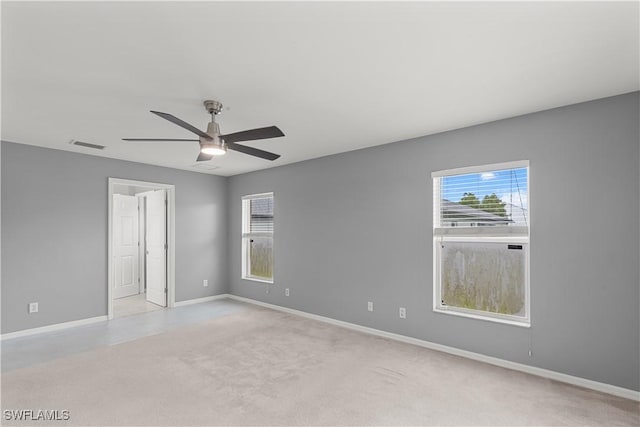 unfurnished room featuring light carpet, ceiling fan, and a healthy amount of sunlight