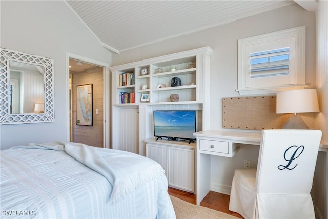bedroom featuring built in study area and vaulted ceiling