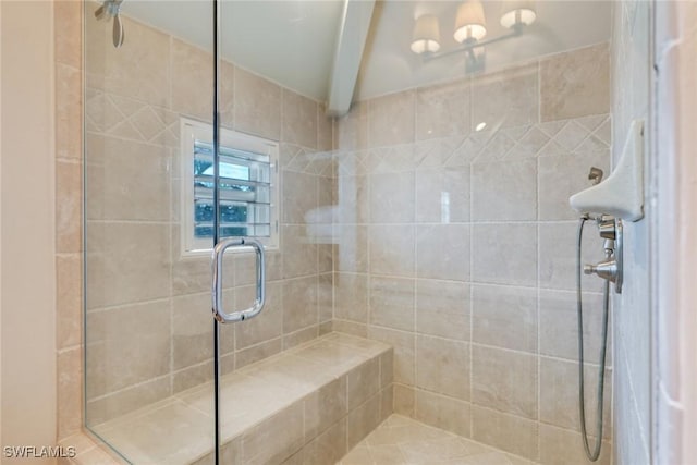 bathroom featuring a stall shower and beam ceiling