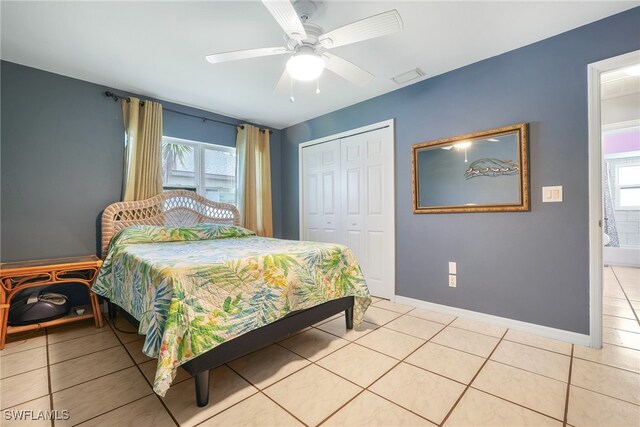 bedroom with a closet, ceiling fan, and light tile patterned flooring