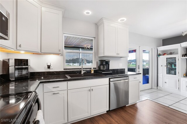 kitchen with white cabinets, appliances with stainless steel finishes, plenty of natural light, and sink