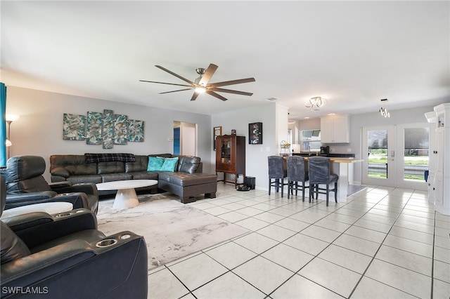 living room featuring light tile patterned floors, a ceiling fan, and baseboards