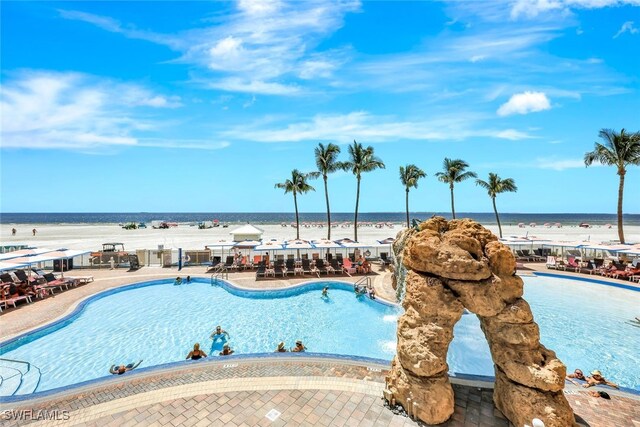 view of pool featuring a water view and a patio