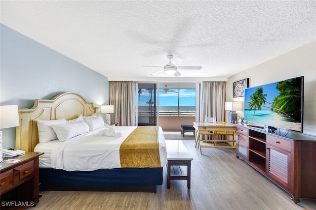 140 Estero Blvd Unit 2105, Fort Myers Beach, FL 33931 - bedroom featuring light wood-style floors, access to outside, a ceiling fan, and a textured ceiling