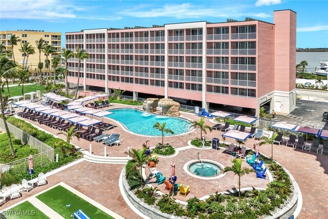 view of property with a community pool and a water view