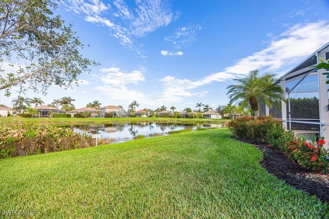 view of yard with a water view and a lanai