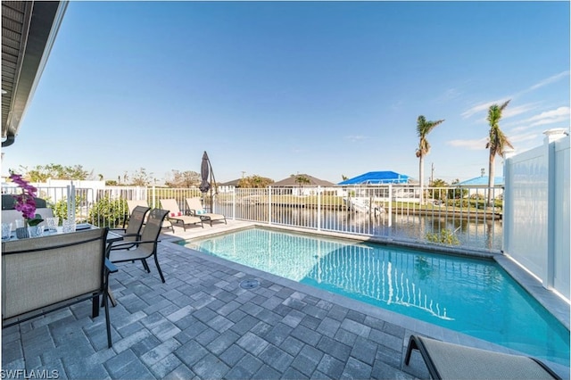 view of pool featuring a water view and a patio area