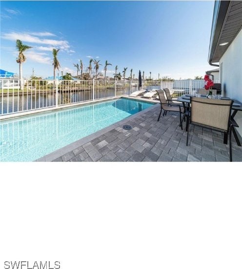 view of pool featuring a patio and a water view