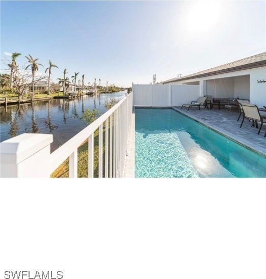 view of swimming pool with a water view and a patio area