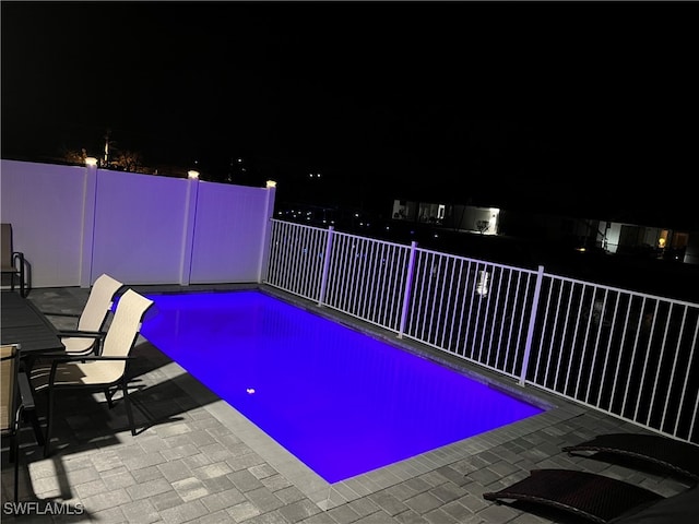 pool at twilight with a patio area