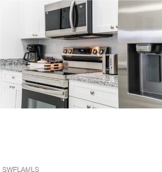 kitchen with light stone countertops, stainless steel appliances, and white cabinets