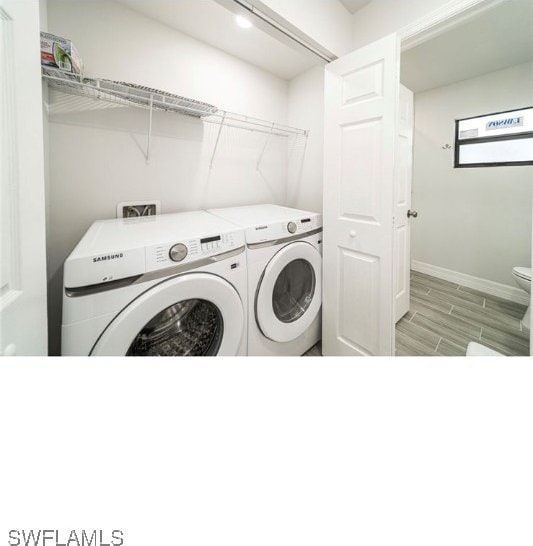 clothes washing area featuring separate washer and dryer and light hardwood / wood-style flooring