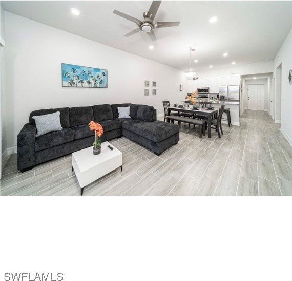 living room featuring light hardwood / wood-style flooring and ceiling fan