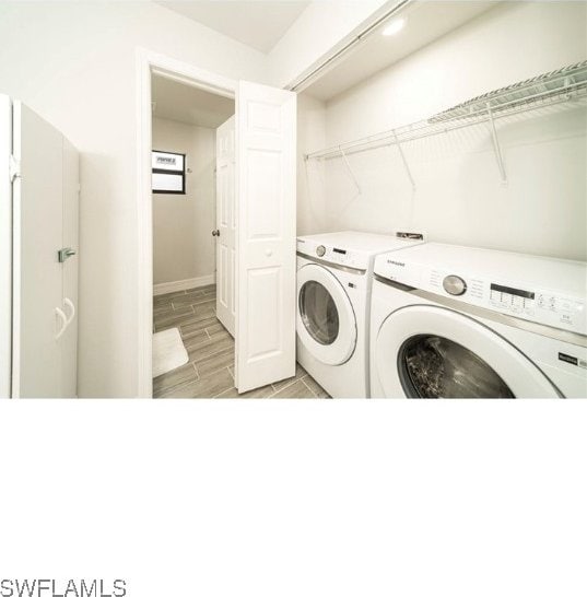 laundry area with light hardwood / wood-style floors and washer and dryer